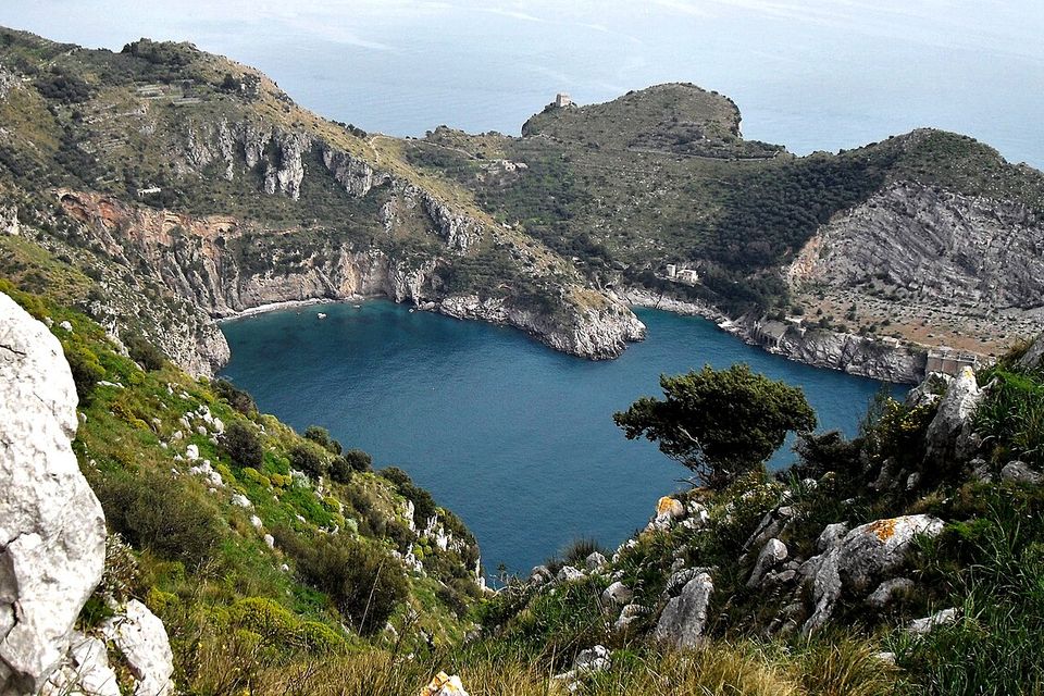 Ieranto Bay seen from above, framed by rocky headlands and Mediterranean vegetation.