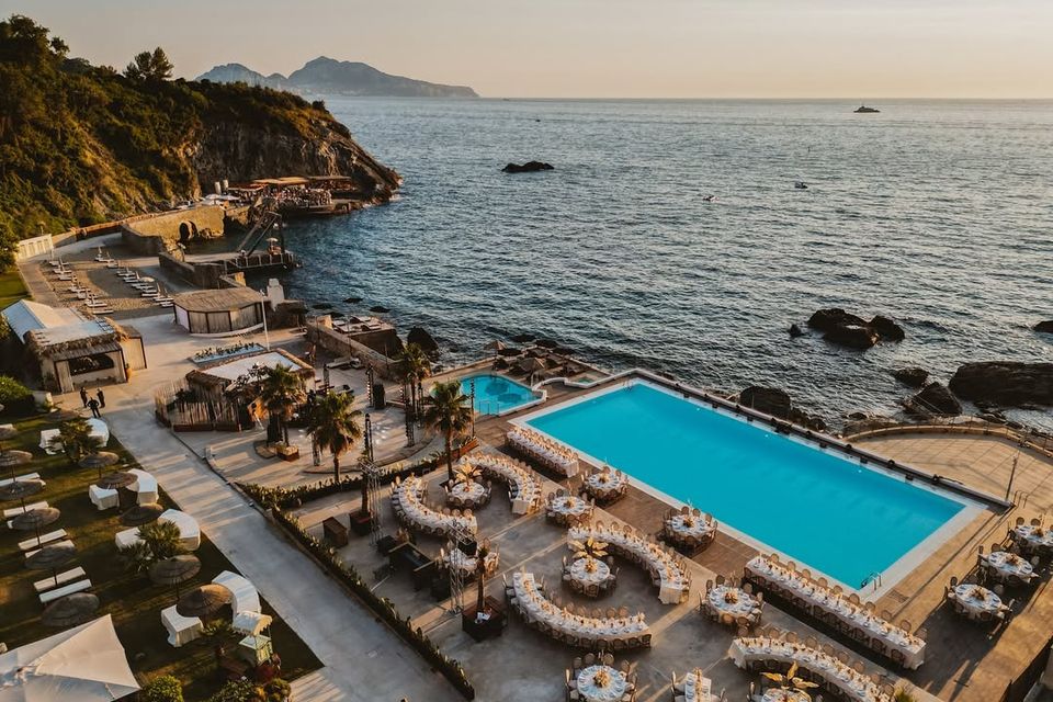 The pool and seafront terraces at Maya Beach Experience, with Capri in the background.