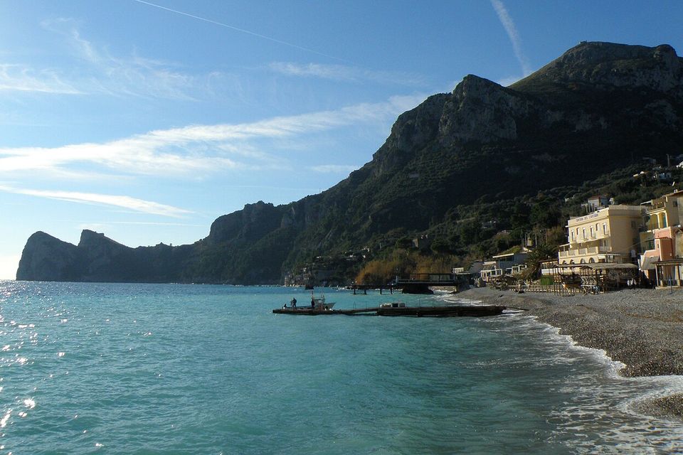 The pebble beach at Marina del Cantone, with the sea and headland in the background.