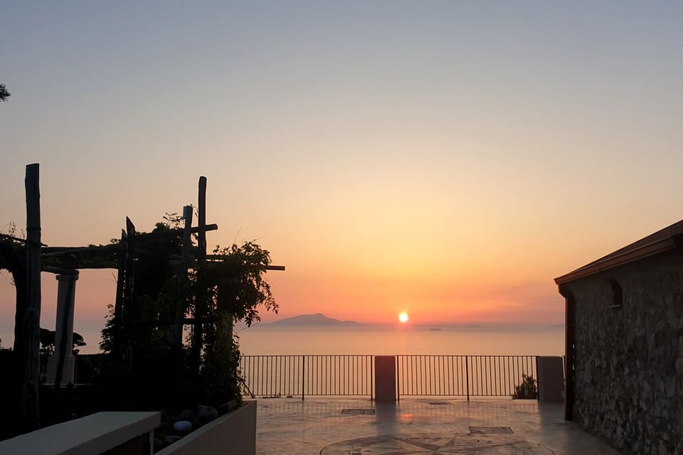 The terrace at Palazzo Raja overlooking the sea at sunset.