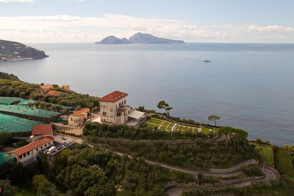 Villa Angelina and its gardens overlooking the sea, with Capri in the background.